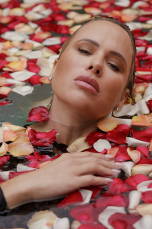 fine art editorial woman portrait in water on a bed of rose petals