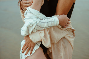mother and daughter embrace on beach lifestyle photoshoot
